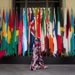 A woman walks by a long row of flags at the IMF building during the 2026 annual IMF/World Bank Spring Meetings in Washington, D.C., U.S., April 16, 2026. REUTERS/Ken Cedeno/File Photo
